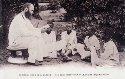 Missionnaire en Afrique : un membre de la société missionnaire des Pères Blancs enseignant à des enfants dans une école d&#039;Afrique équatoriale. Carte postale des années 1930 ©Collection Sirot-Angel/leemage / © Wikimedia Commons